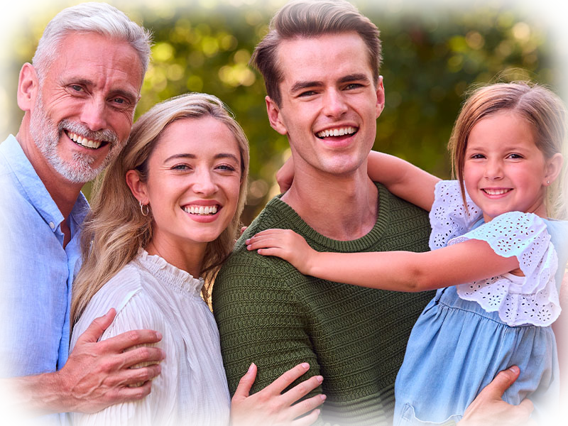 Happy multi-generational family smiling outdoors — family dentistry in Cornwall