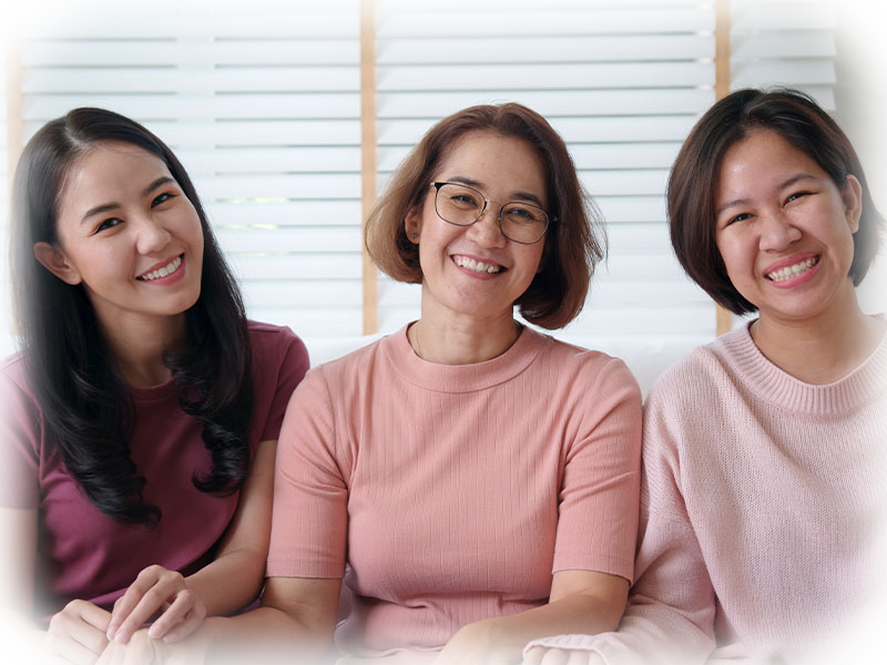 Three smiling women together — healthy gums and confident smiles