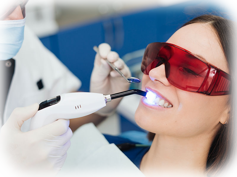 Dentist performing a soft-tissue dental laser treatment with protective eyewear